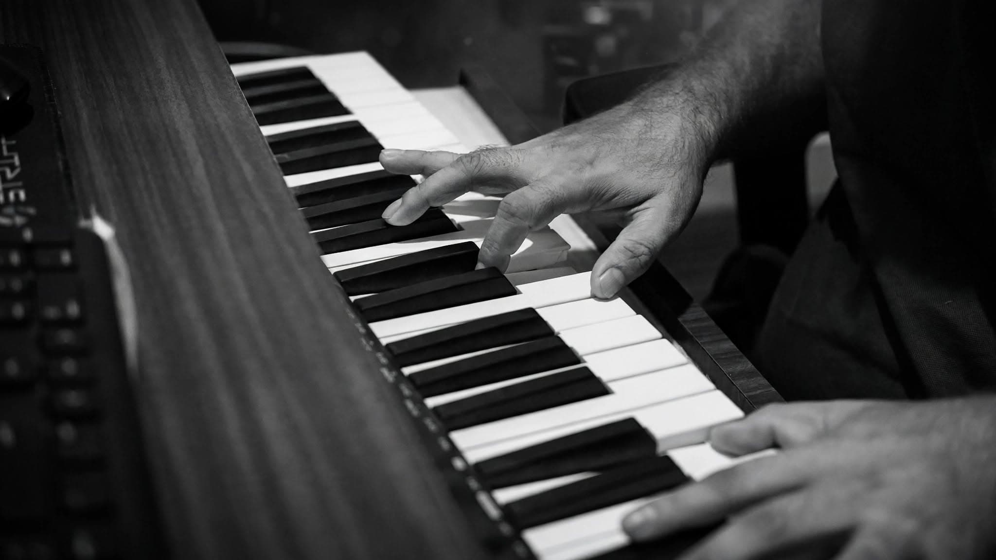 Close-up of hands playing a keyboard during a recording session at NS Music Production